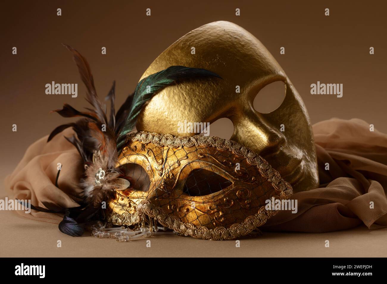 Goldene venezianische Karnevalsmasken. Vintage-Masken auf beigefarbenem Hintergrund. Stockfoto