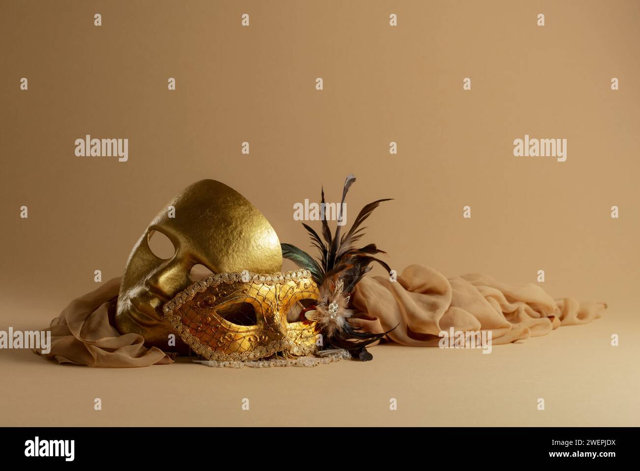 Goldene venezianische Karnevalsmasken. Vintage-Masken auf beigefarbenem Hintergrund. Kopierbereich. Stockfoto