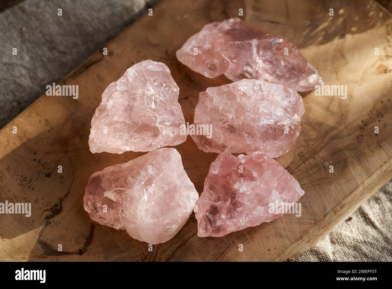 Rosafarbene Quarzsteine auf einem Holztisch Stockfoto