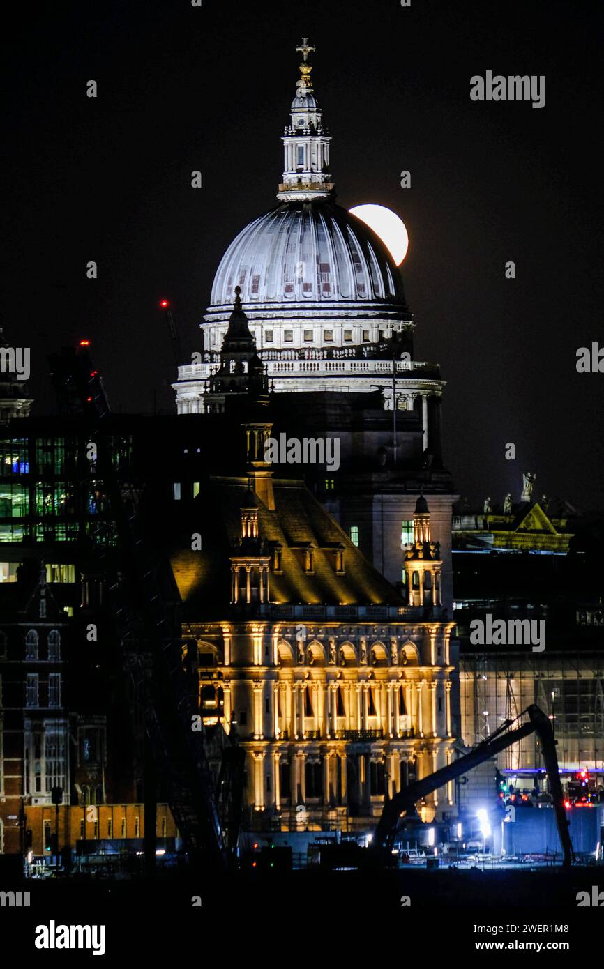 London, Großbritannien. Januar 2024. Ein Mond von 98,8% stieg hinter der St. Paul's Cathedral auf. Der Wolf Moon im Januar soll nach den verstärkten Voakalisationen der Lebewesen in den langen und dunklen Winternächten benannt werden. Quelle: Eleventh Photography/Alamy Live News Stockfoto