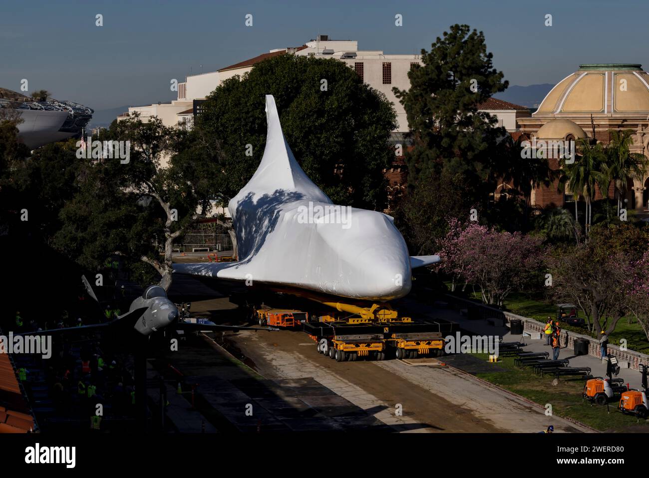 Los Angeles, USA. Januar 2024. Das Space Shuttle Endeavour wird für ein letztes 20-stöckiges vertikales Stapelverfahren im California Science Center verlegt. Das 122 Meter lange Shuttle war in weißes Kunststoffmaterial eingewickelt, um es während seiner letzten Reise zu schützen. 26/2024 Los Angeles, CA., USA (Foto: Ted Soqui/SIPA USA) Credit: SIPA USA/Alamy Live News Stockfoto