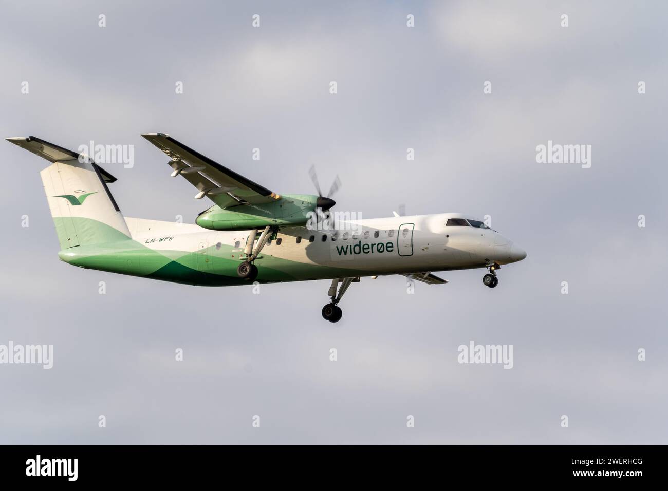 Ein norwegisches Flugzeug der Wideroe Airlines im Flug durch den klaren blauen Himmel Stockfoto