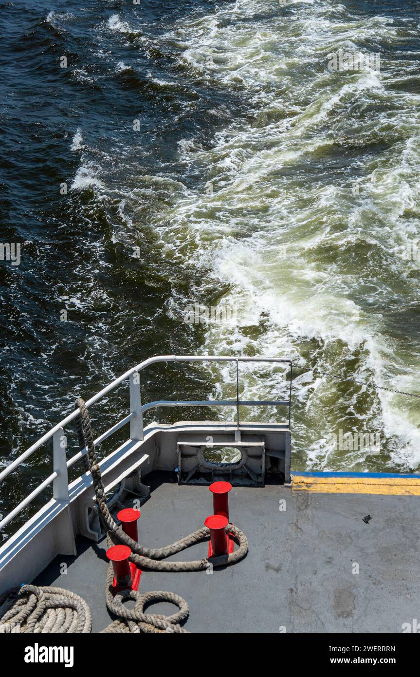 Eine Passagierfähre mit Wassermotorboot, die unter einem sonnigen Sommernachmittagstag auf dem blauen Wasser der Guanabara-Bucht einen großen Wasserschein und Schaum macht. Stockfoto