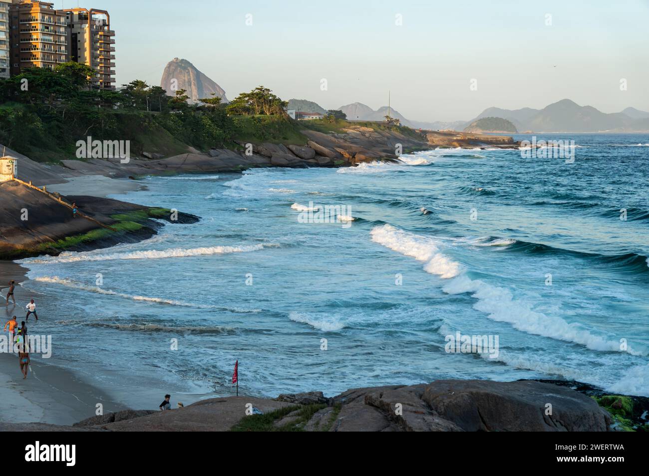 Teilweiser Blick auf den Strand Praia do Diabo, wie er vom Felsen Pedra do Arpoador zwischen den Bezirken Ipanema und Copacabana unter dem Sommernachmittag am klaren blauen Himmel gesehen wird. Stockfoto