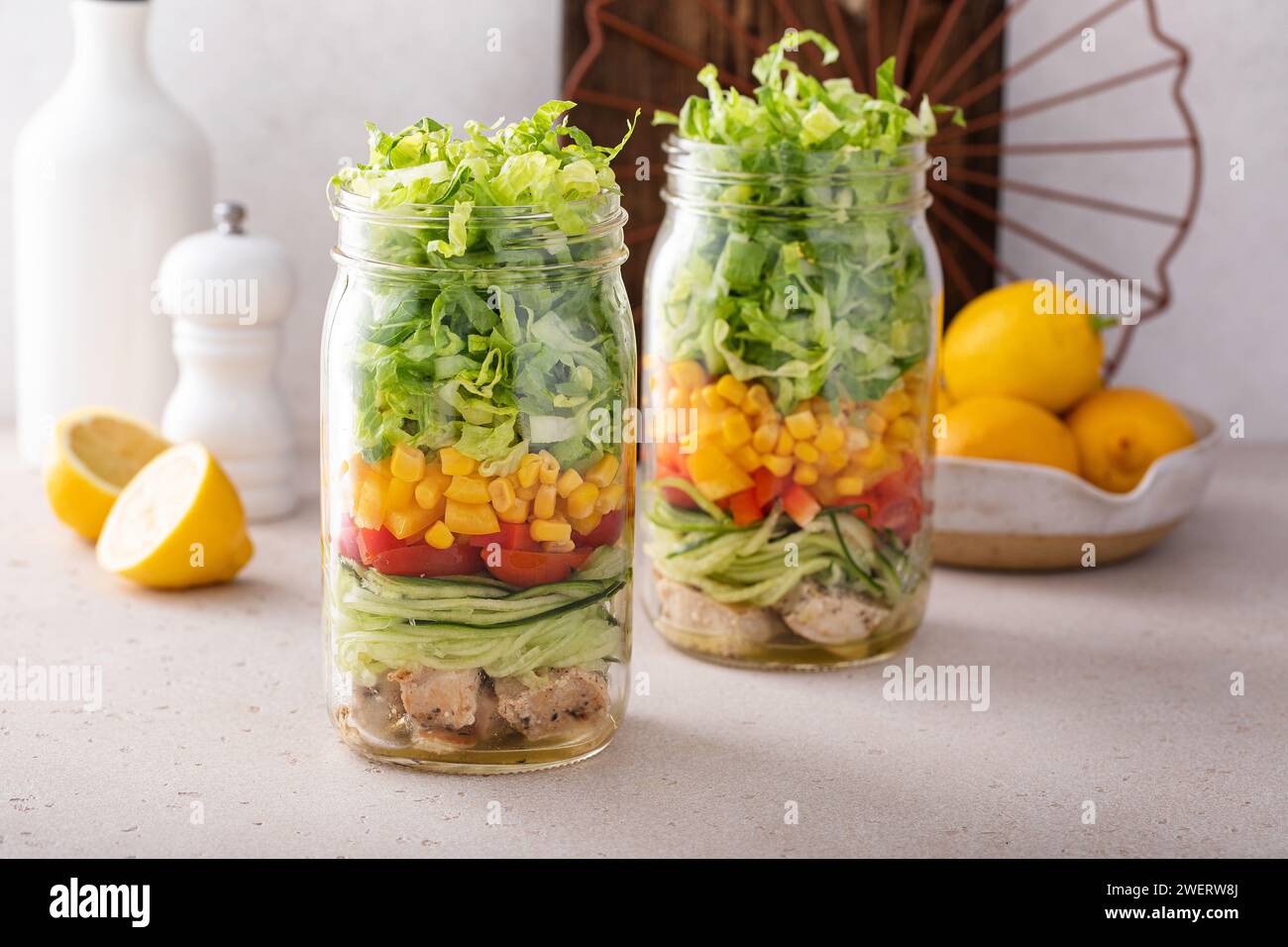 Zubereitung der Mahlzeit für das Mittagessen, gesunder Salat in einem Glas mit frischem Gemüse und gegrilltem Huhn Stockfoto