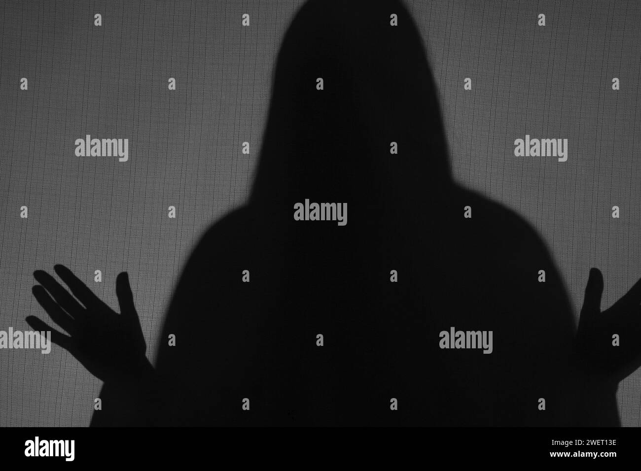 Silhouette eines gruseligen Geistes hinter grauem Tuch Stockfoto