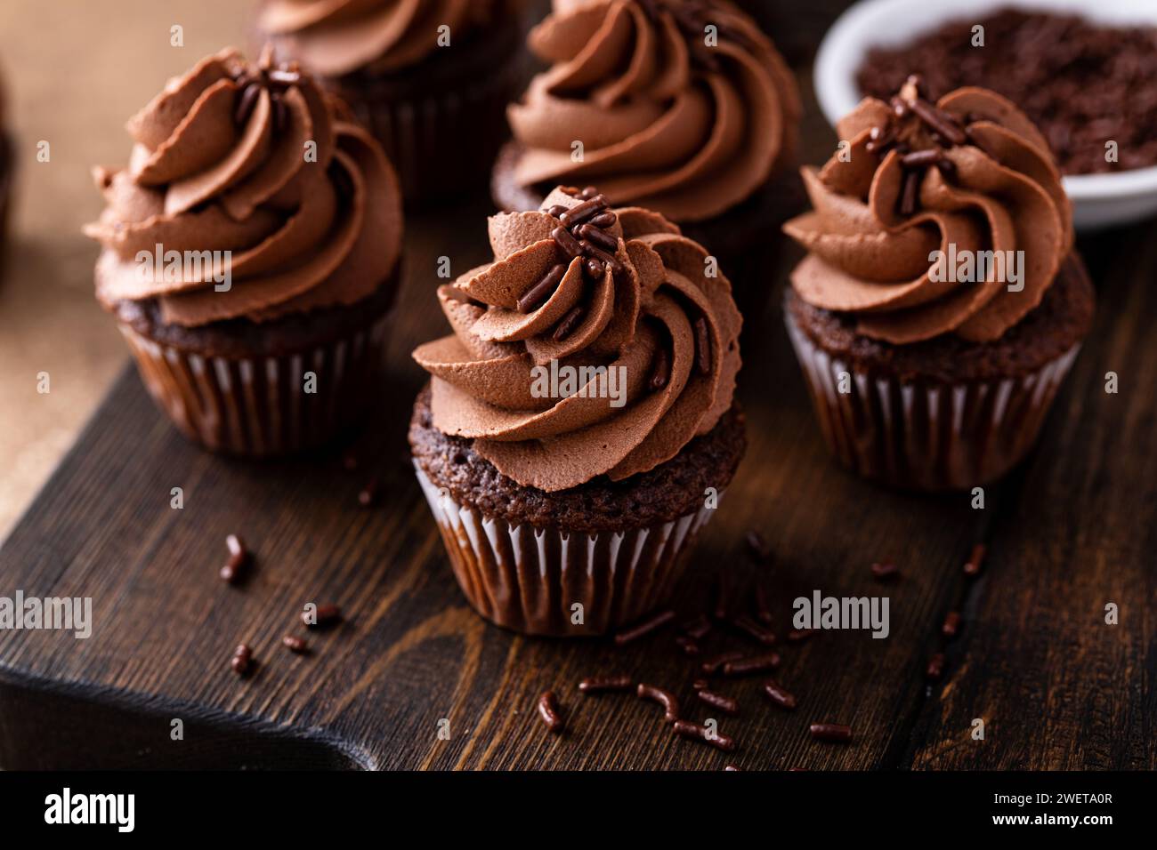 Cupcakes aus dunkler Schokolade mit Schokoladenganache und Schokoladenstreuseln Stockfoto