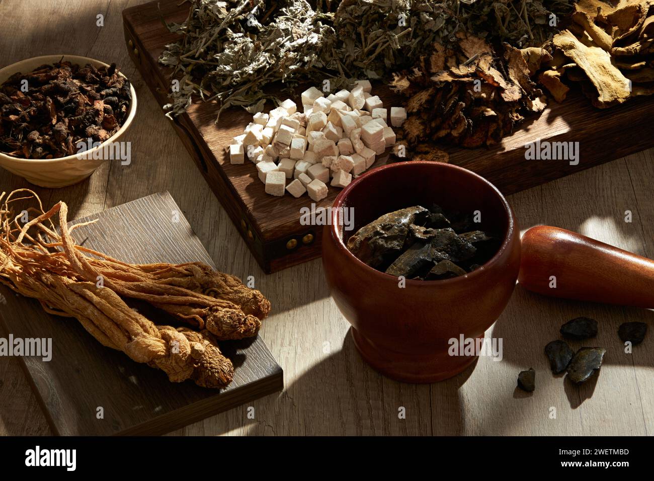 Blick von oben auf traditionelle Kräuter auf hölzernem Tablett, Podium, Schüssel, Mörtel und Stößel auf hölzernem Tischhintergrund. Kräutersammlung zur Herstellung von a t Stockfoto