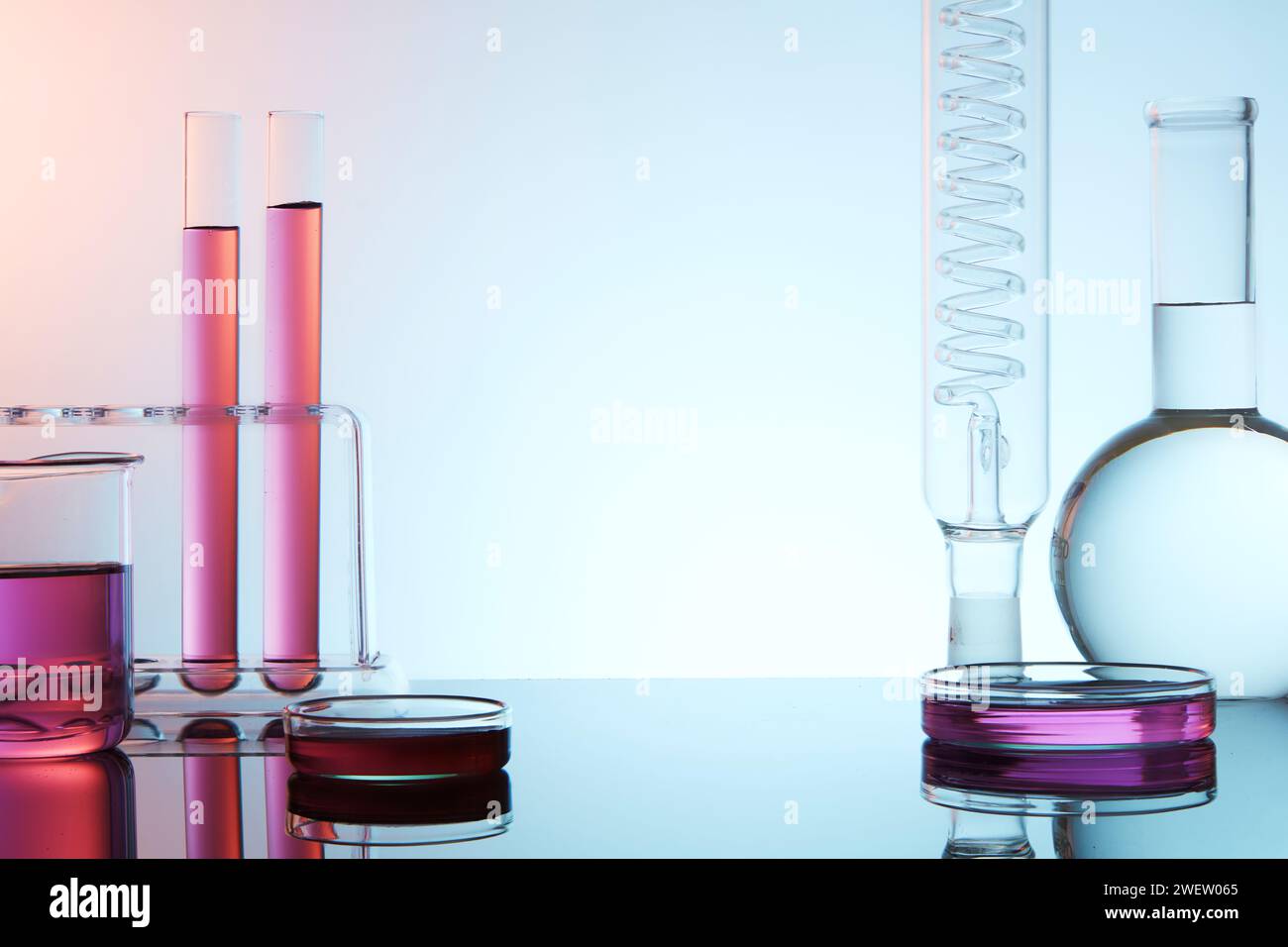 Vorderansicht der Laborglaswaren gefüllt mit bunter Flüssigkeit auf hellem Hintergrund. Leeres Leerzeichen für Produkt und Text anzeigen. Wissenschaftliche Laborforschung und Entwicklung Stockfoto