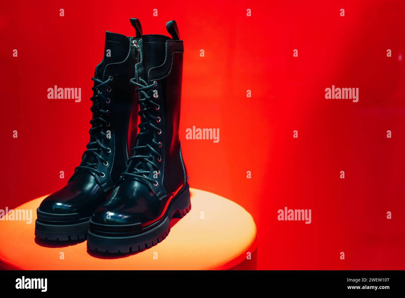 Schwarze Damen-Schnürschuhe aus Lackleder auf einem Boutique-Stand auf rotem Hintergrund. Kopierbereich Stockfoto