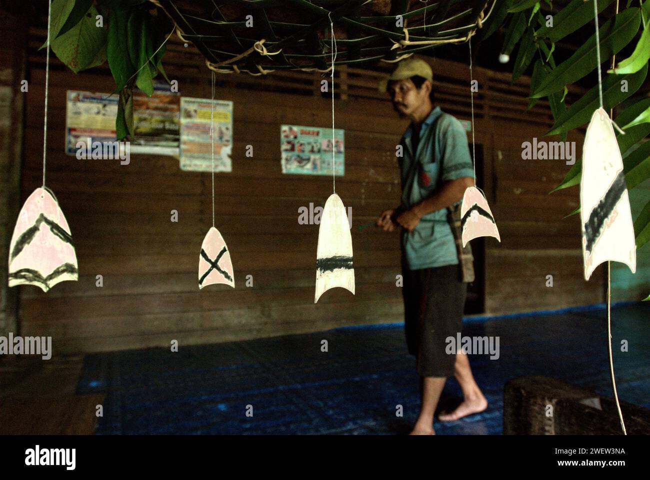Stücke traditioneller dekorativer Holzschnitzereien hängen unter einem Opferkorb im Langhaus der Gemeinde Dayak Tamambaloh Apalin im Dorf Sungai Uluk Palin (Sungulo Palin), Putusibau Utara, Kapuas Hulu, West Kalimantan, Indonesien. Kultur ist ein unverzichtbarer Bestandteil jeder Entwicklung, wenn sie nachhaltig sein soll, und es ist von entscheidender Bedeutung, dass jeder Mensch und jede Gemeinschaft ihre kulturellen Rechte frei ausüben kann, so eine Pressemitteilung der Vereinten Nationen vom Oktober 2022. „Kultur ist eine Möglichkeit und ein Motor für nachhaltige Entwicklung“, so Alexandra Xanthaki, Expertin für kulturelle Rechte. Stockfoto