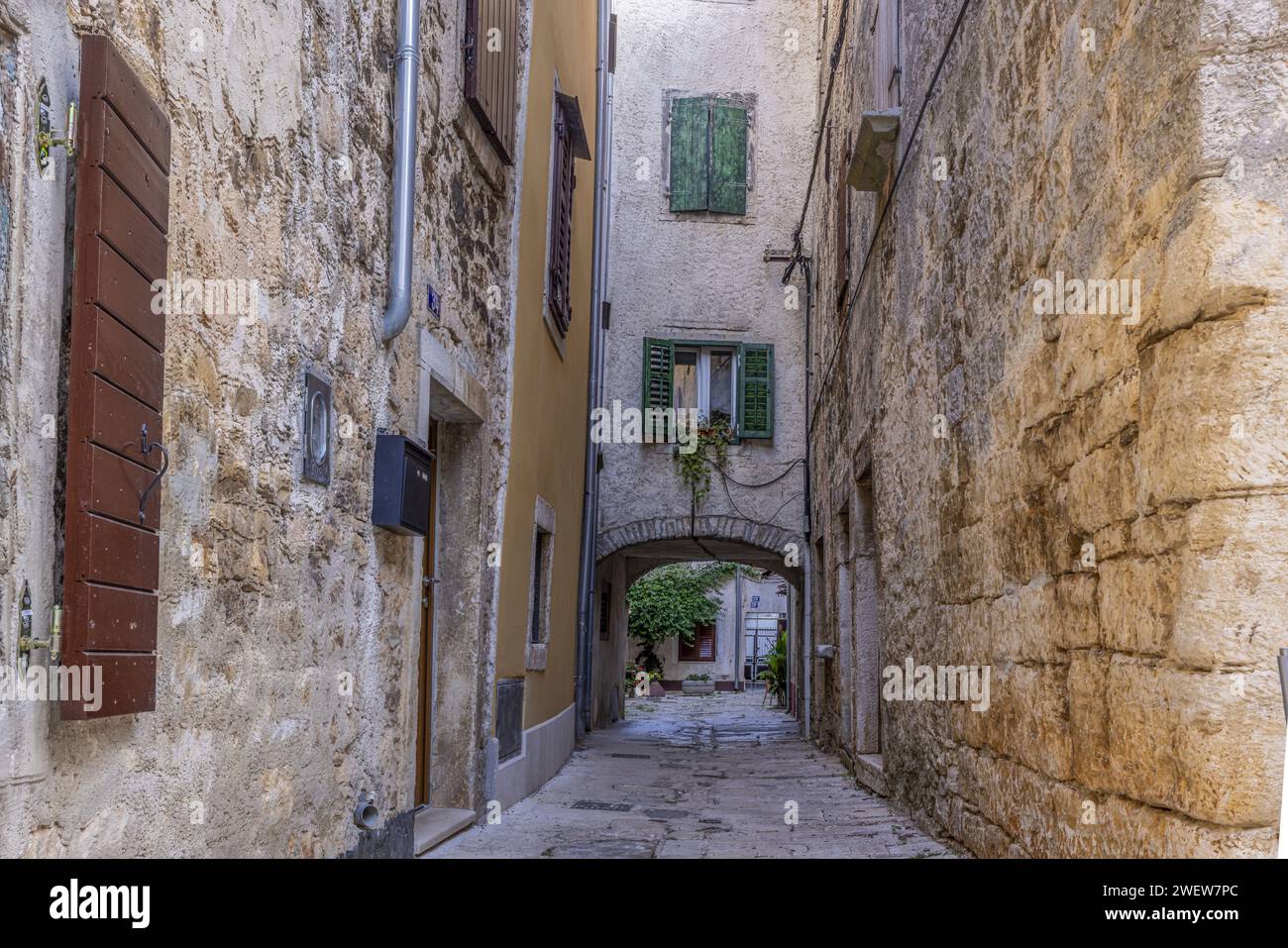Bild einer typischen Straßenszene aus der historischen kroatischen Stadt Voznjan mit Kopfsteinpflasterstraßen und alten Gebäuden im Morgenlicht Stockfoto