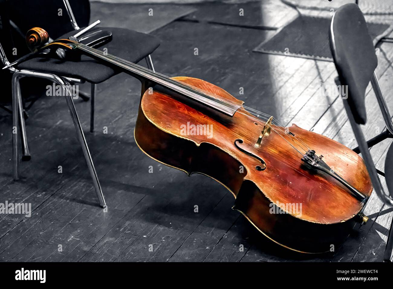 Das Bild eines Streichmusikinstrumentes eines Symphonieorchesters das Cello liegt auf der Theaterbühne Stockfoto