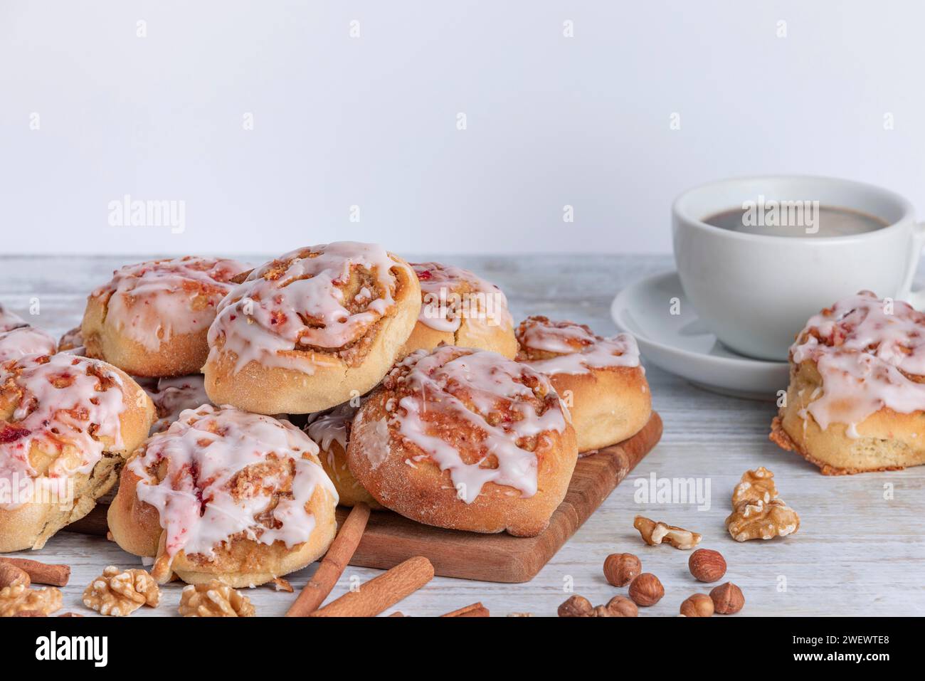 Einladendes Frühstück mit Zimtbrötchen und einer Tasse Kaffee auf einem Holztisch Stockfoto