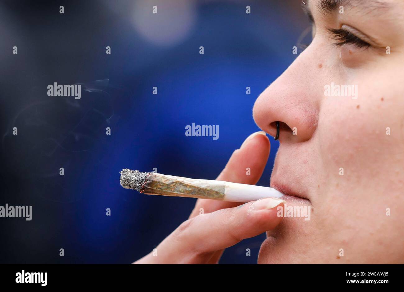 Eine Frau raucht einen Joint während einer Demonstration für legalen Marihuana-Konsum. Die Demonstranten fordern die Legalisierung und sofort Stockfoto