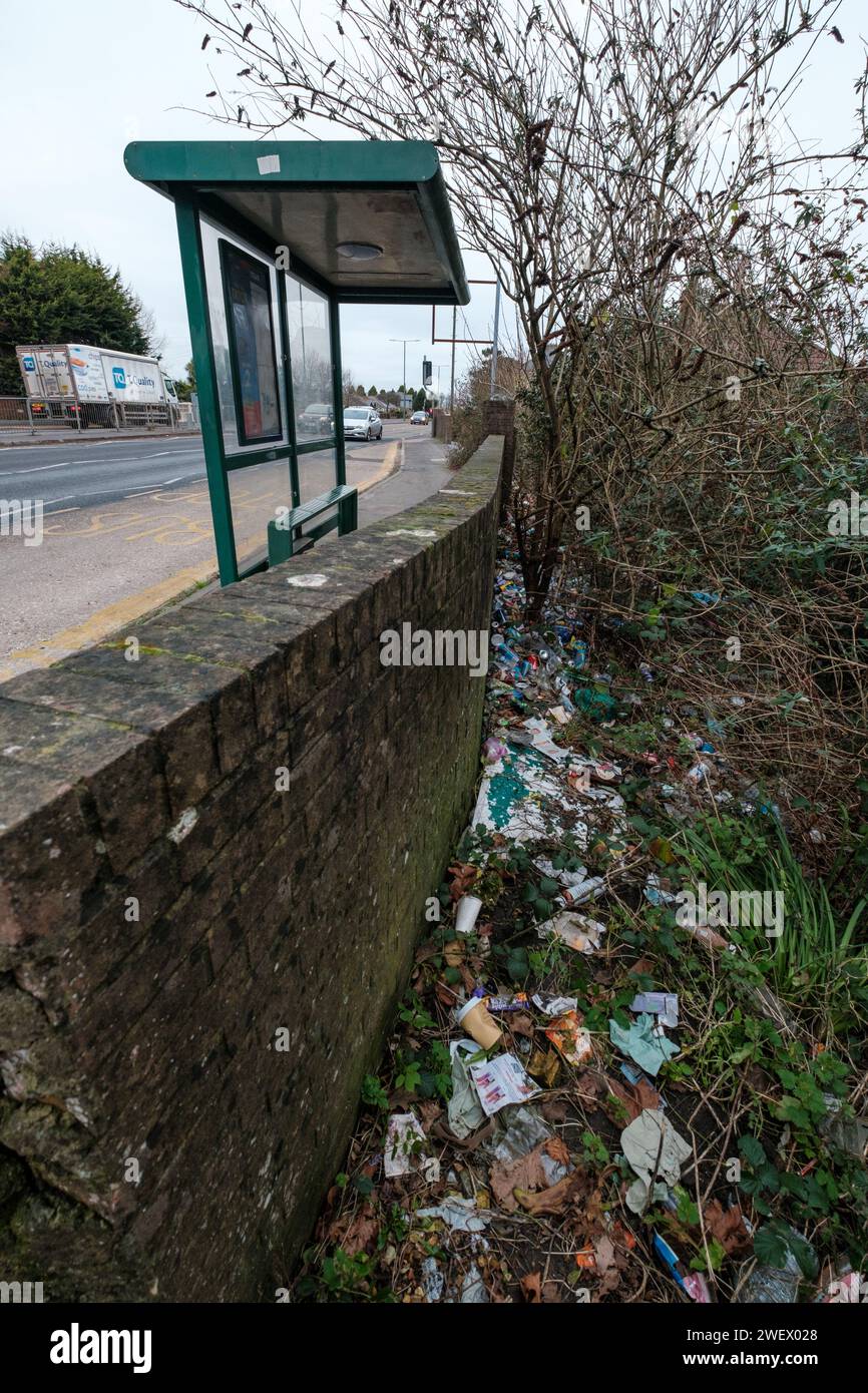 Müll wurde an einer Bushaltestelle in der Wallisdown Road in Bournemouth Dorset entsorgt. An der Bushaltestelle gibt es keinen Abfalleimer, so dass die Gegend schwer ist mit Müll, der von Pendlern weggeworfen wird. Stockfoto