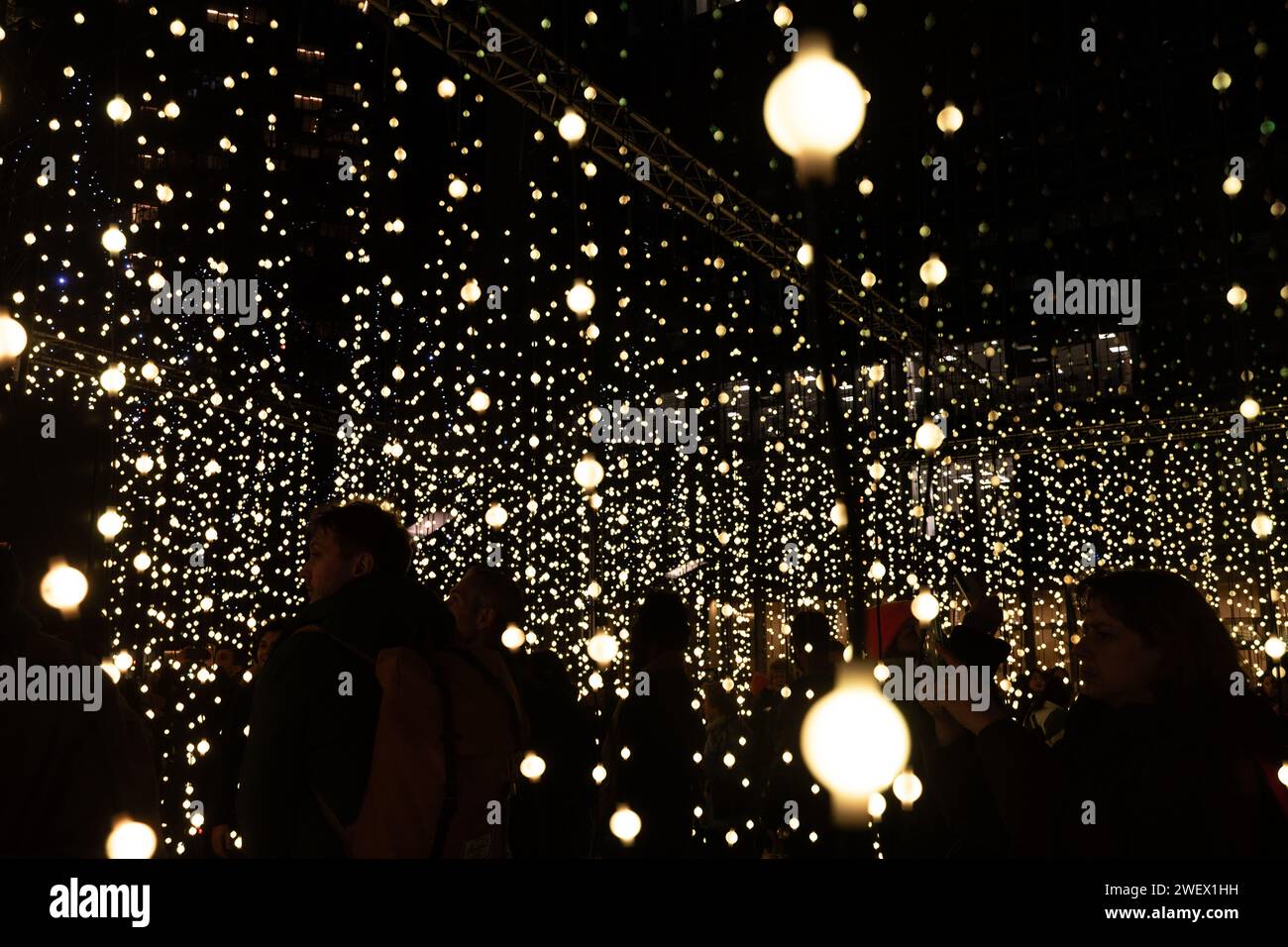 Canary Wharf Winter Lights, 26. Januar 2024, das beliebte Canary Wharf Winter Lights Festival findet vom 17. Bis 27. Januar 2024 in London statt und bietet 13 farbenfrohe Lichtinstallationen. Im Bild: Menschen, die das immersive Kunsterlebnis „Submergence by Squidsoup“ am Montgomery Square genießen Stockfoto