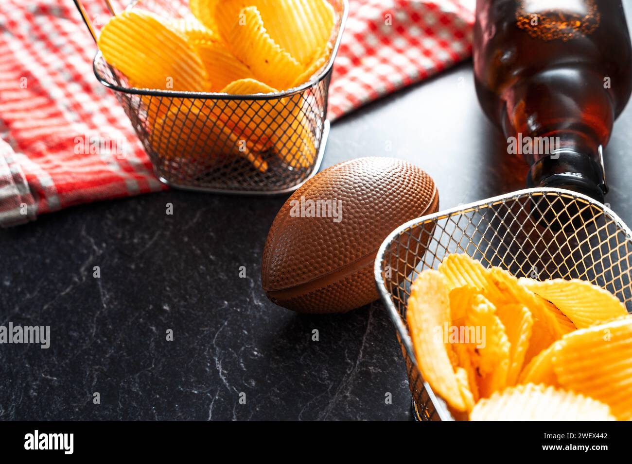 Bayern, Deutschland - 26. Januar 2024: American Football Super Bowl Symbolbild, Fußball mit Snacks wie Chips und Bier *** American Football Super Bowl Symbolbild, Fußball mit Snacks wie Chips und Bier Stockfoto