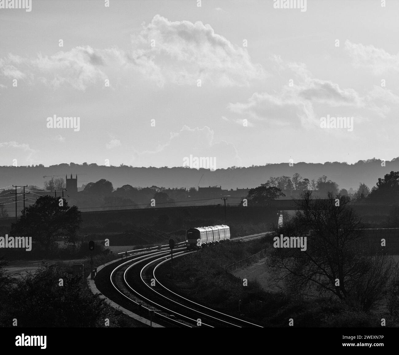 Der Zug der Chiltern Railways Class 168 Clubman fährt über Charlton-on-Otmoor auf der Bicester-Verbindung an einem Teil der Varsity-Eisenbahnstrecke vorbei und fängt den Sonnenuntergang ein Stockfoto