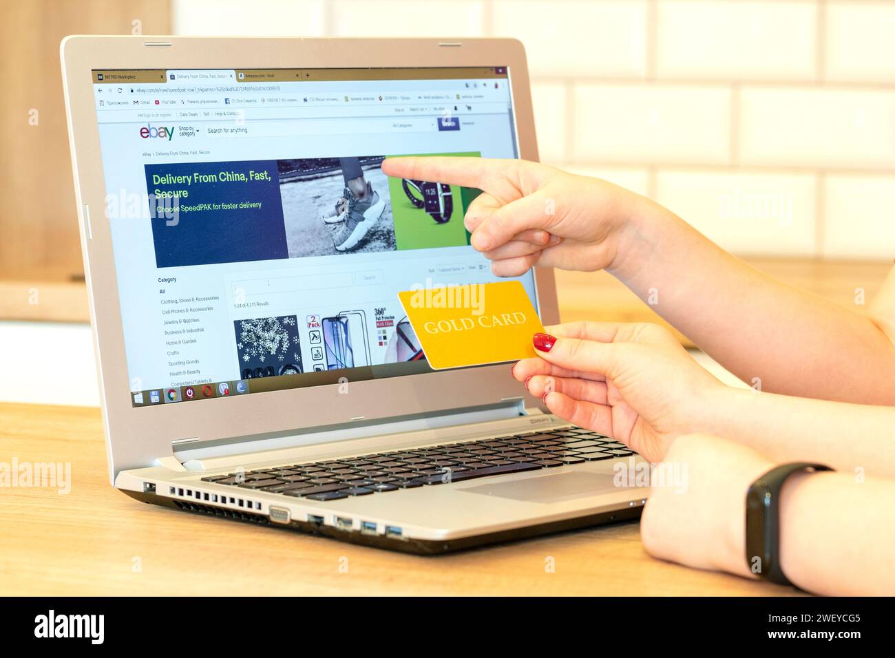 Hand mit einer Karte auf einem Laptop-Hintergrund. Menschen wählen und kaufen Waren online. Shopper.Concept Online-Shopping, Sales.Concept Käufer. Shopper, Shopping Stockfoto