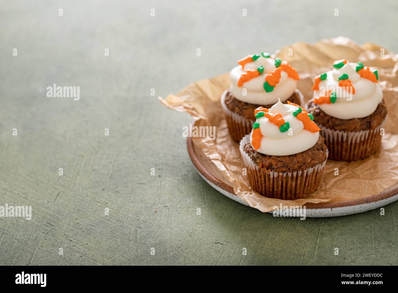 Karottenkuchen Cupcakes mit Frischkäse-Zuckerguss, dekoriert mit kleinen Karotten Stockfoto
