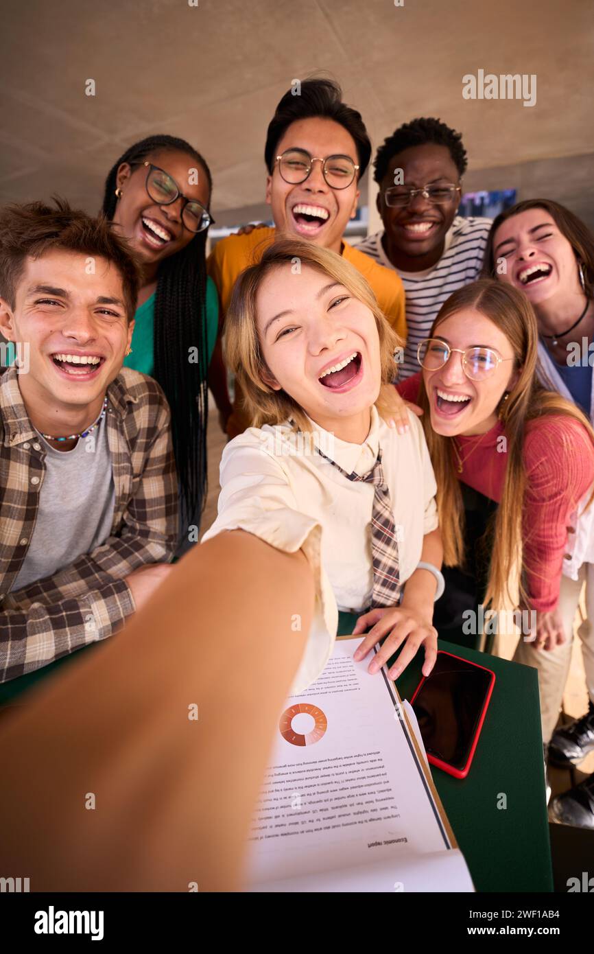 Eine große Gruppe lächelnder und fröhlicher junger multirassischer Universitätsstudenten, die ein Selfie machen Stockfoto
