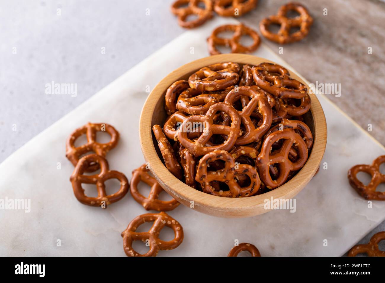Knusprige Mini-Brezeln mit Salz in einer Holzschale, salzige Snackidee Stockfoto