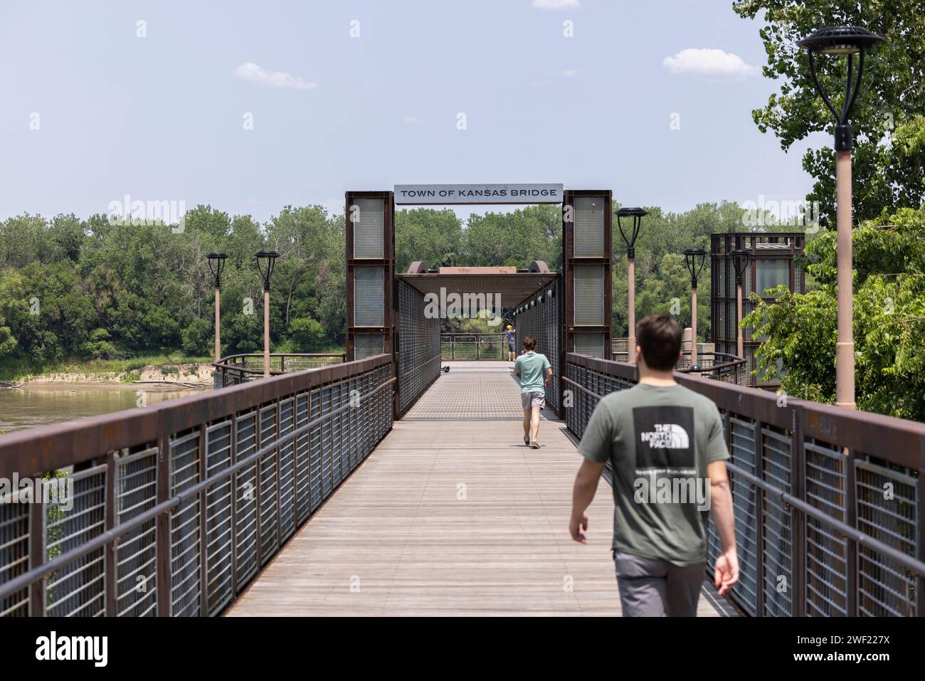 Kansas City, Missouri, USA – 15. Juni 2023: Die Leute wandern auf der Town of Kansas Bridge auf dem Riverfront Heritage Trail entlang des Missouri River. Stockfoto