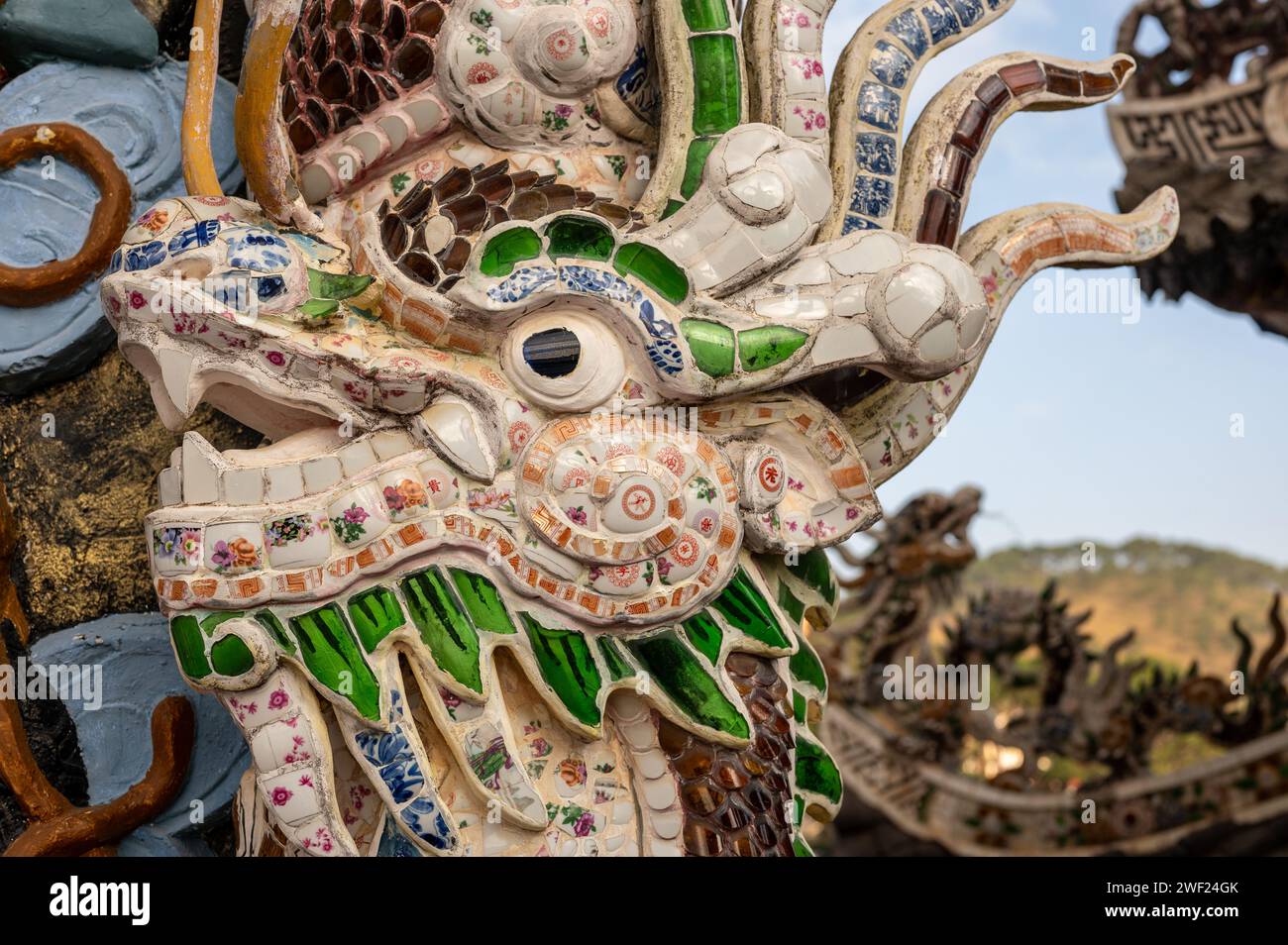 Atemberaubende Drachenskulptur mit lebendigen Mosaikfliesen schmückt das Dach der Pagode als fesselndes architektonisches Element. Komplexe Details und satte Farben. Stockfoto