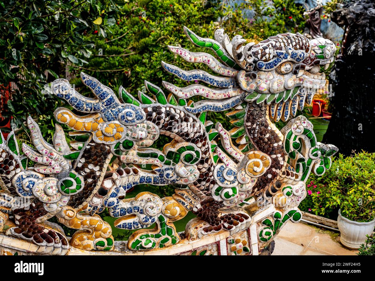 Atemberaubende Drachenskulptur mit lebendigen Mosaikfliesen schmückt das Dach der Pagode als fesselndes architektonisches Element. Komplexe Details und satte Farben. Stockfoto