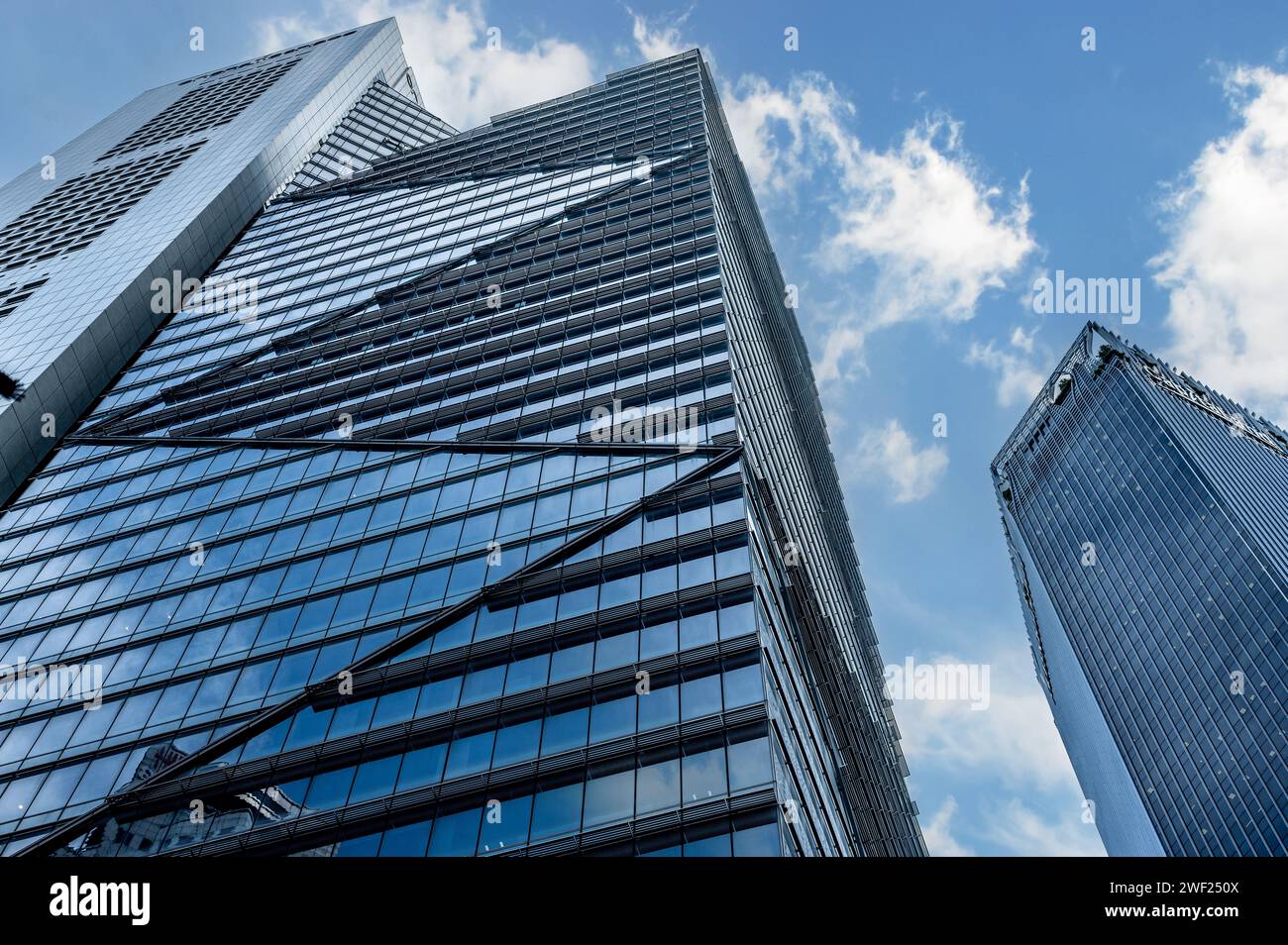 Singapur, 24. Januar 2024: Wolkenkratzer, Symbole der globalen Wirtschaft, erheben sich gegen blauen Himmel und Wolken. Hoch aufragende Strukturen verkörpern die Dominanz des Unternehmens Stockfoto