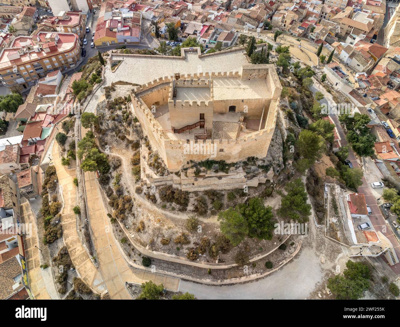 Blick aus der Vogelperspektive auf Petrer, mittelalterliche Stadt und Burg auf einem Hügel mit restauriertem Turm und Zinnen in der Nähe von Elda Spanien, Stockfoto