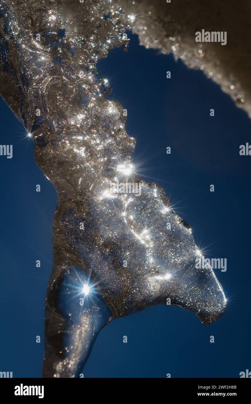 Gefrorene Eiszapfen und glänzende Kristalle auf eisiger Oberfläche Stockfoto