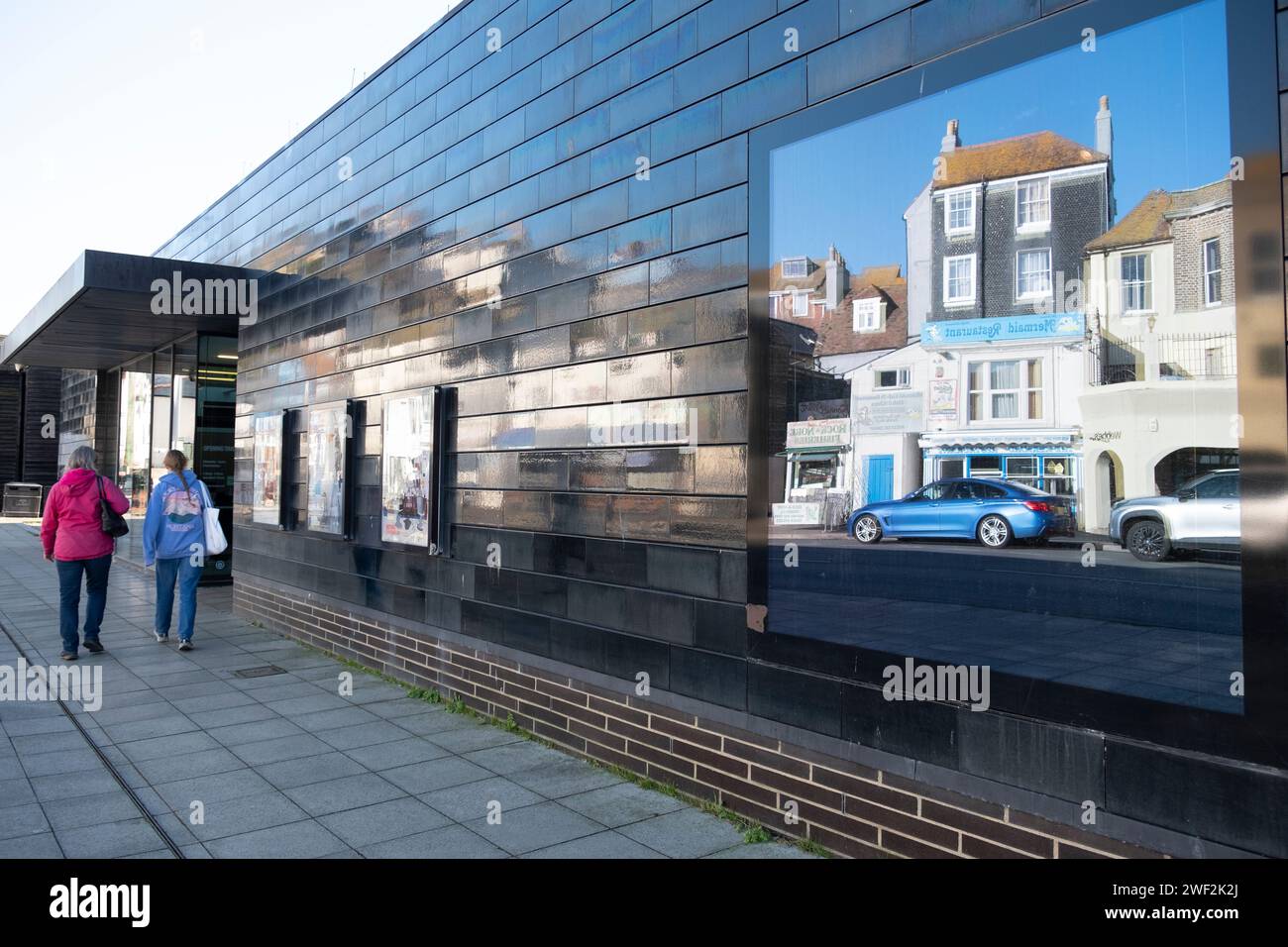 Hastings Contemporary Art Gallery, die das schwarz gekachelte Lavender House gegenüber in East Sussex, Großbritannien, widerspiegelt Stockfoto