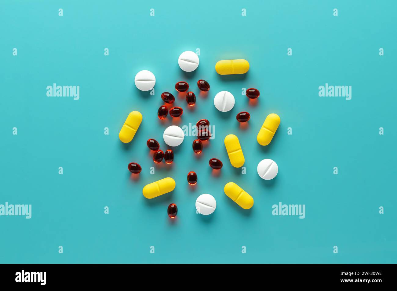 Bunte medizinische Pillen auf blauem Hintergrund, verschiedene Tabletten Nahaufnahme, Ansicht von oben. Haufen verschiedener Nahrungsergänzungsmittel. Wunderschönes Muster, zentrale Ausstattung Stockfoto