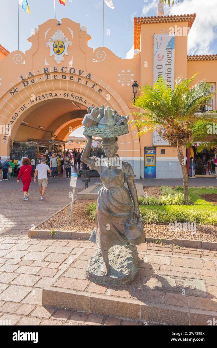Lechera Canaria ist eine Statue einer Frau, die einen Korb mit Milchkannen auf dem Kopf und einem Milchkännchen in der Hand vor dem Markt von Los Christianos trägt. Stockfoto