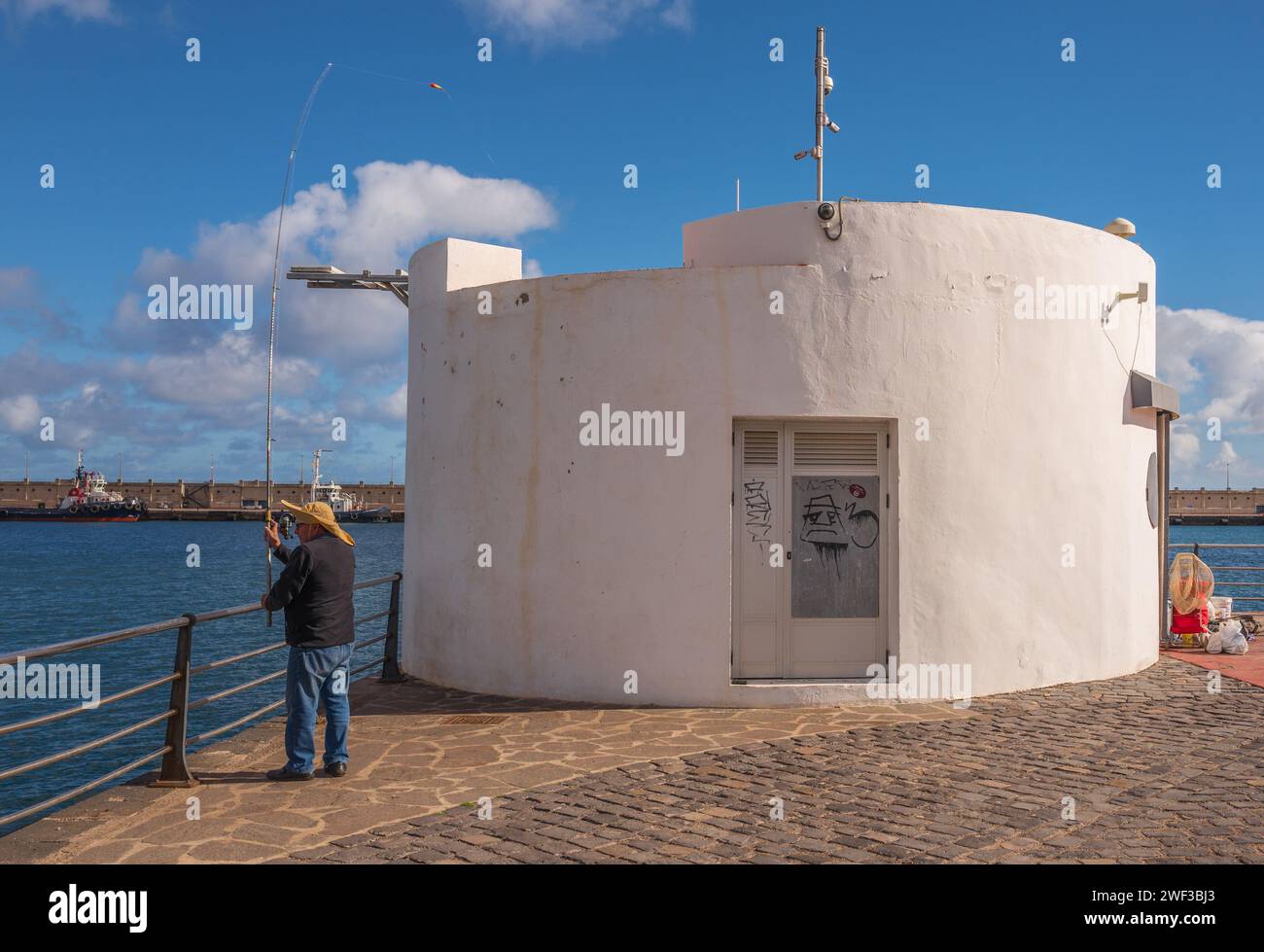 Lokale Fischer fischen vor dem Kai am Hauptkreuzterminal in Santa Cruz, Teneriffa auf den Kanarischen Inseln. Stockfoto