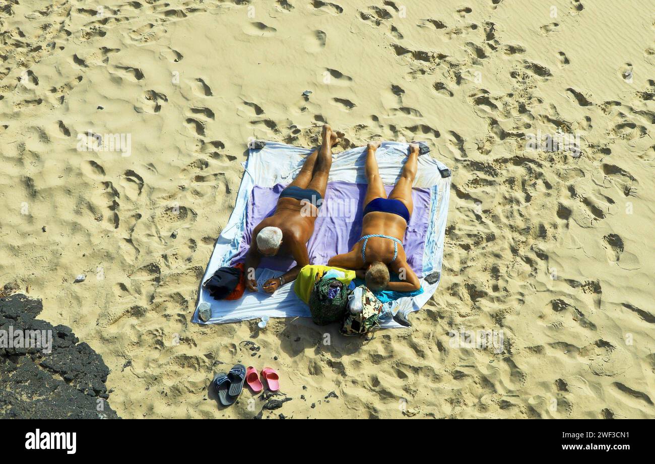 Sonnenbaden auf einer Decke am Strand von Jandia auf Fuerteventura-Süd am 16.01.2018 *** Sonnenbaden auf einer Decke am Strand von Jandia in Fuerteventura Süd am 16 01 2018 Stockfoto