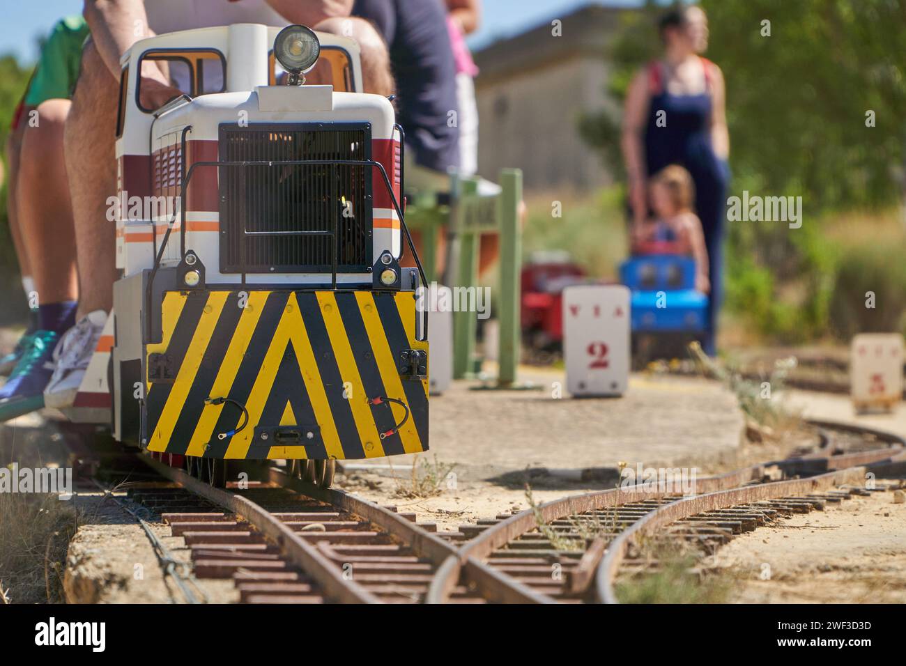 Menschen unterschiedlichen Alters, die mit einem elektrischen Freizeitzug unterwegs sind Stockfoto