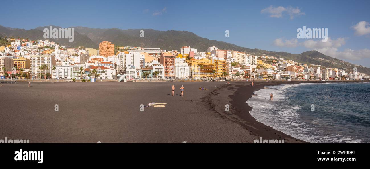 Sonnenanbeter genießen die Wintersonne und Wärme auf dem schwarzen Sand auf der kanarischen Insel Santa Cruz, La Palma, Spanien. Stockfoto