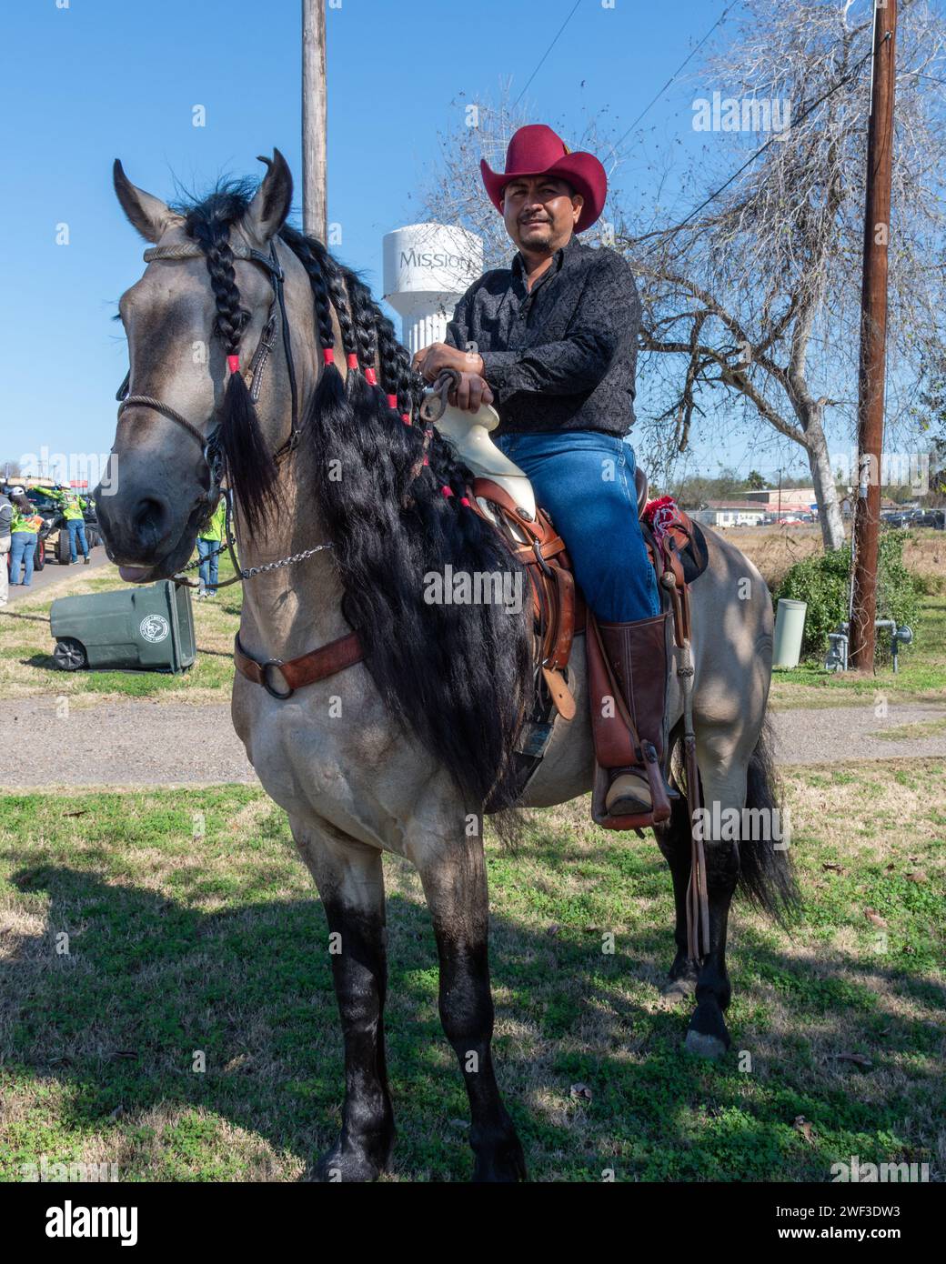 Cowboy sitzt im Sattel auf einem Pferd mit geflochtener Mähne und wartet auf den Beginn der 92. Jährlichen Texas Citrus Fiesta Parade of Oranges, Mission, Texas, USA. Stockfoto