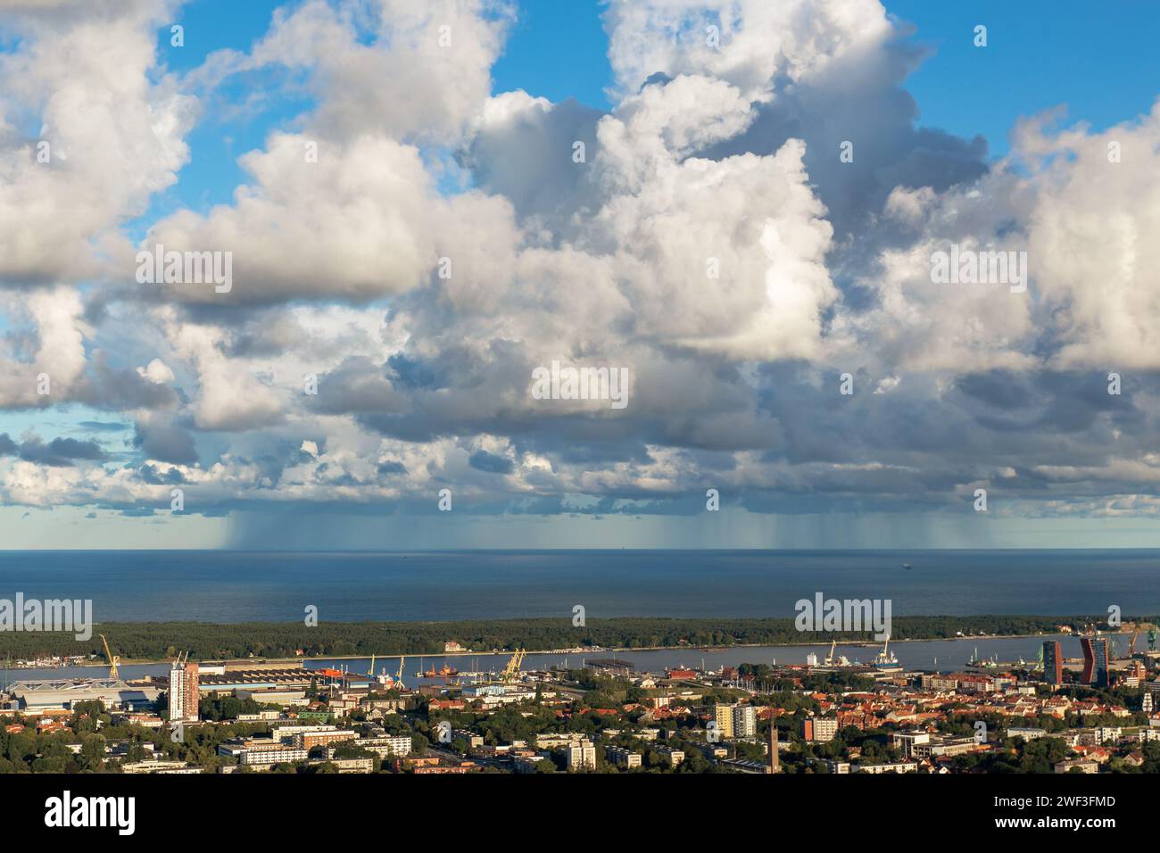 Üppige Wolken an einem Sommermorgen und ein Regenguss in der Ostsee in der Nähe des Hafens von Klaipeda. Stockfoto