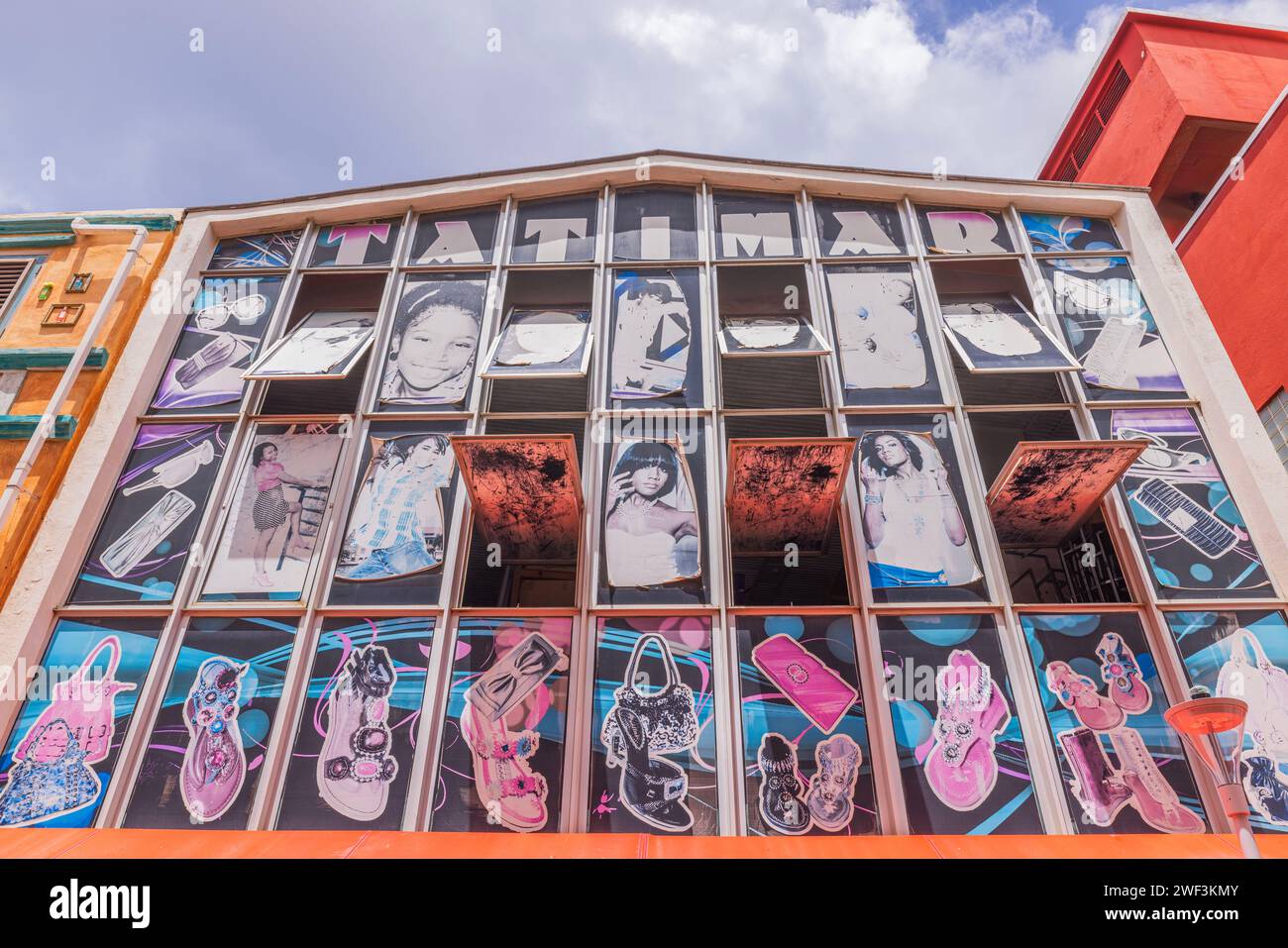 Blick nach unten auf die farbenfrohe Fassade des Tatimor Fashion Center in Curacao vor einem Hintergrund weißer Wolken. Willemstad. Curacao. Stockfoto