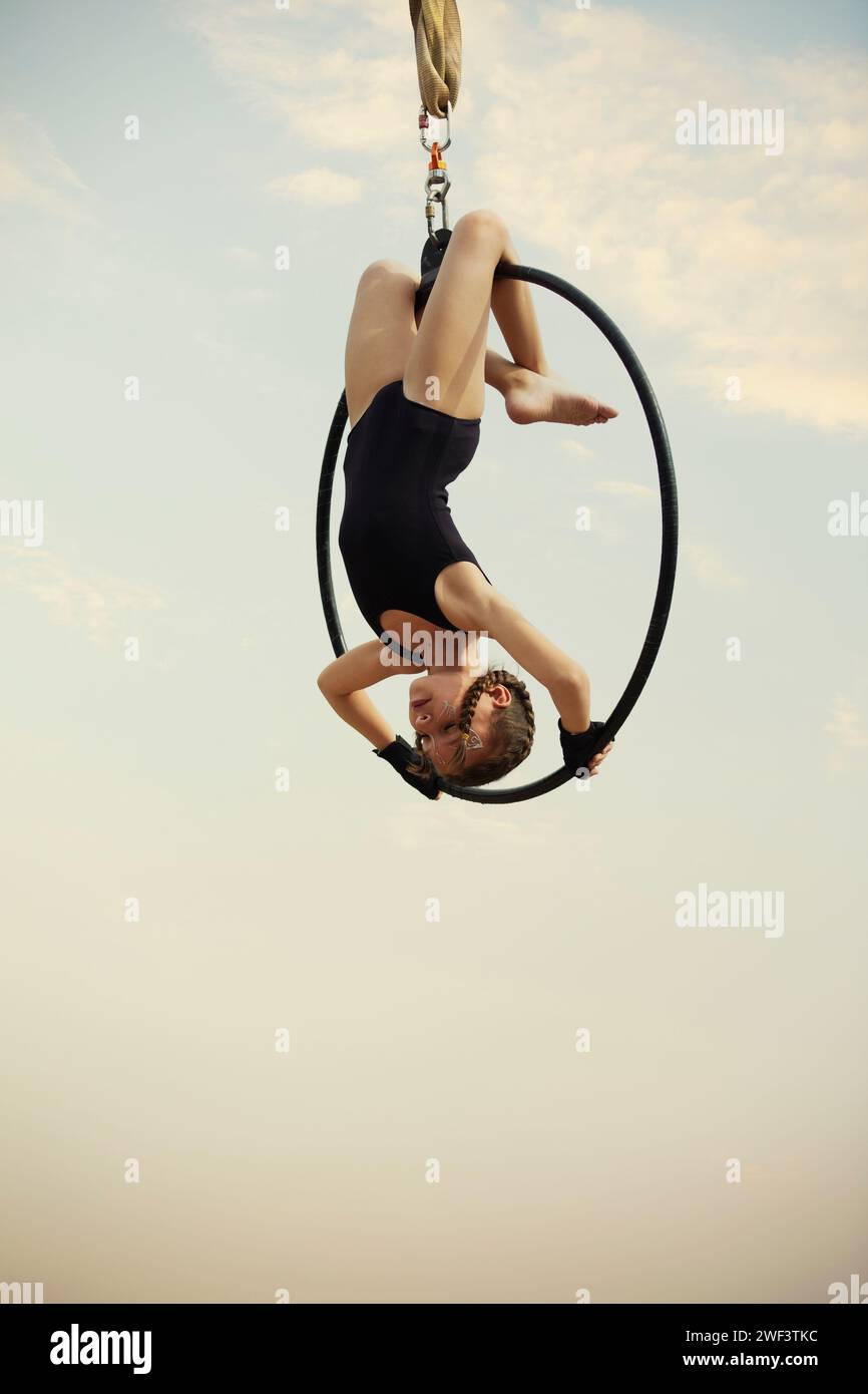 12 Jahre alte Turnerin, die draußen auf einem Luftkorb auftritt Stockfoto