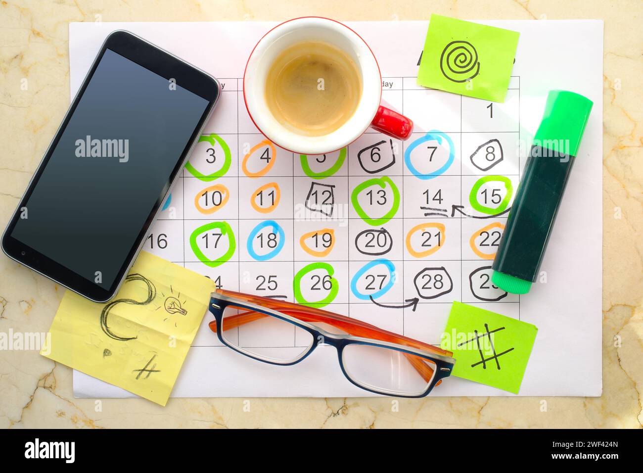Kalender mit Geschäftsterminen, Smartphone, Textmarker, Kaffeetasse und Brille, monatlicher Zeitplan. Business-Konzept, Schlag die Uhr. Stockfoto