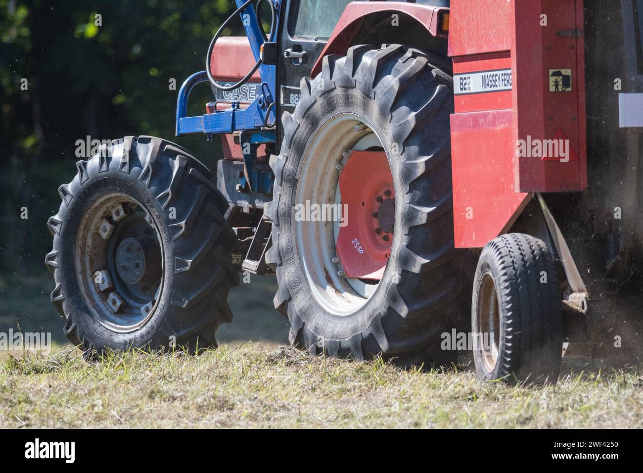 Mähen der Wildblumenwiesen im Herbst in Hawthorn Hive, County Durham. Eine Nahaufnahme der Räder eines Traktors und eines Ballers, der Staub aufwirbelt Stockfoto