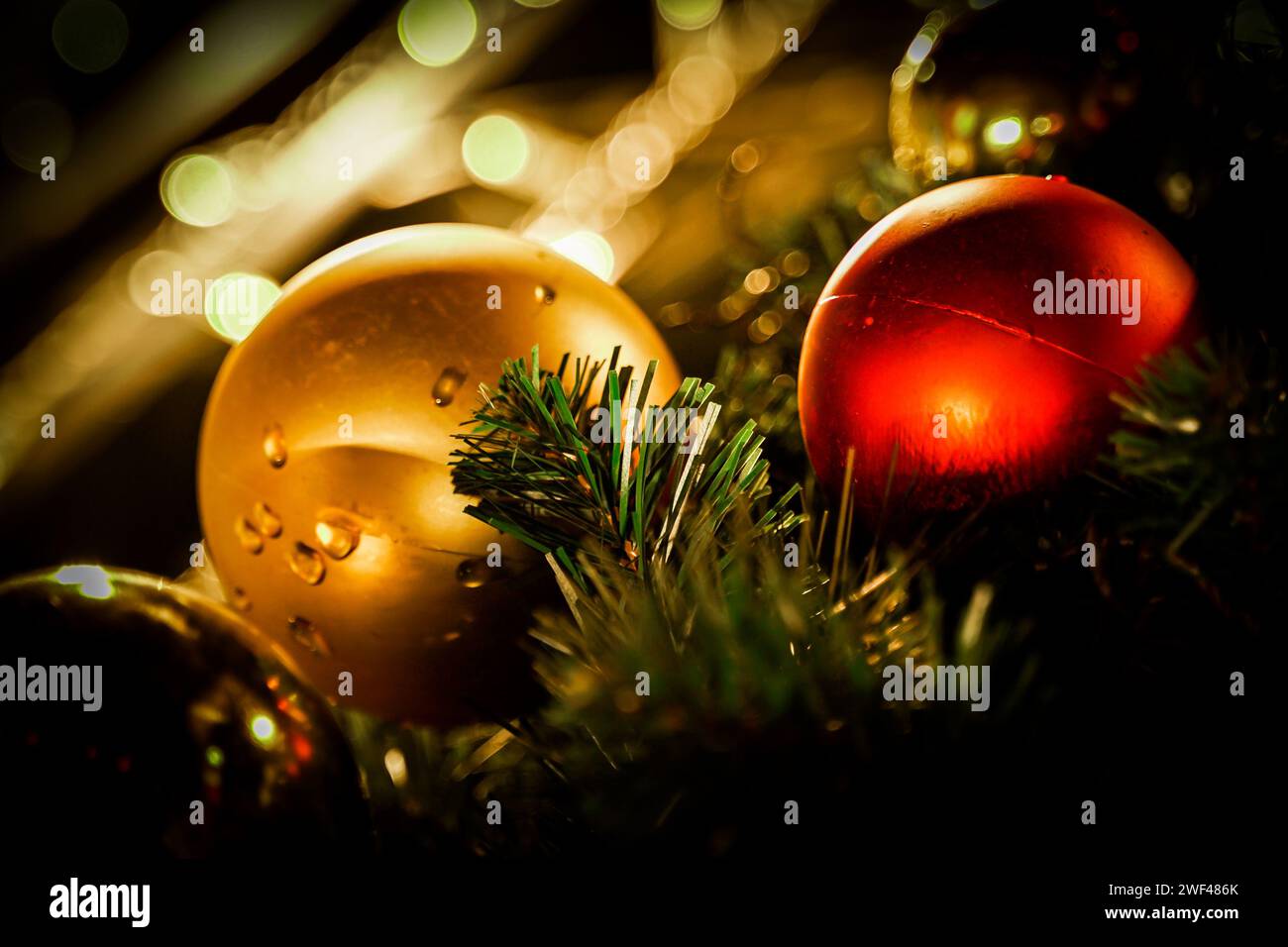 Yuletide Glow: Nahaufnahme festlicher Weihnachtsdekorationen, die in warme Weihnachtslichter getaucht sind Stockfoto