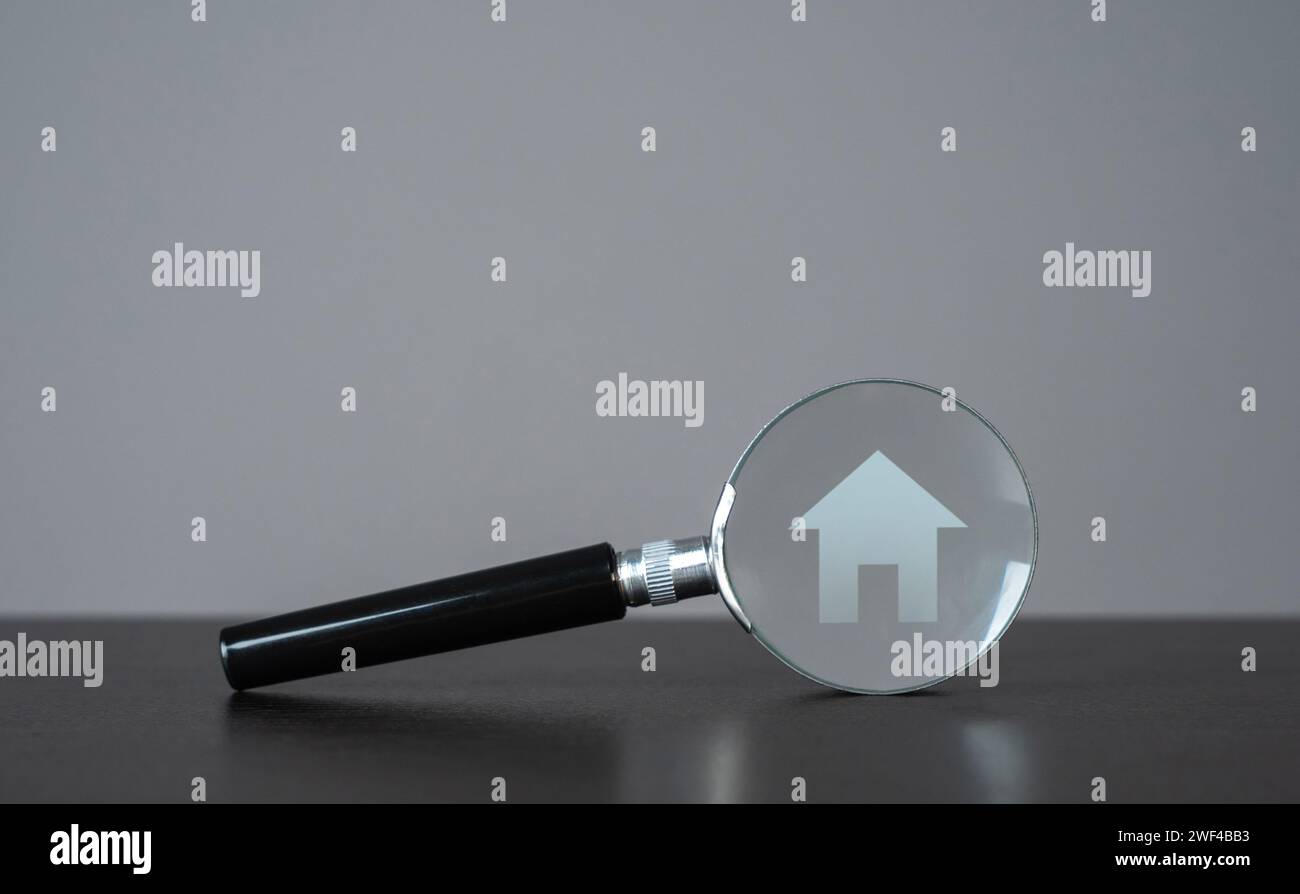 Haus und Lupe. Nehmen Sie eine Hypothek auf. Investitionen in Immobilien. Objektprüfung vor dem Kauf, um Probleme aufzudecken. Suche nach Stockfoto