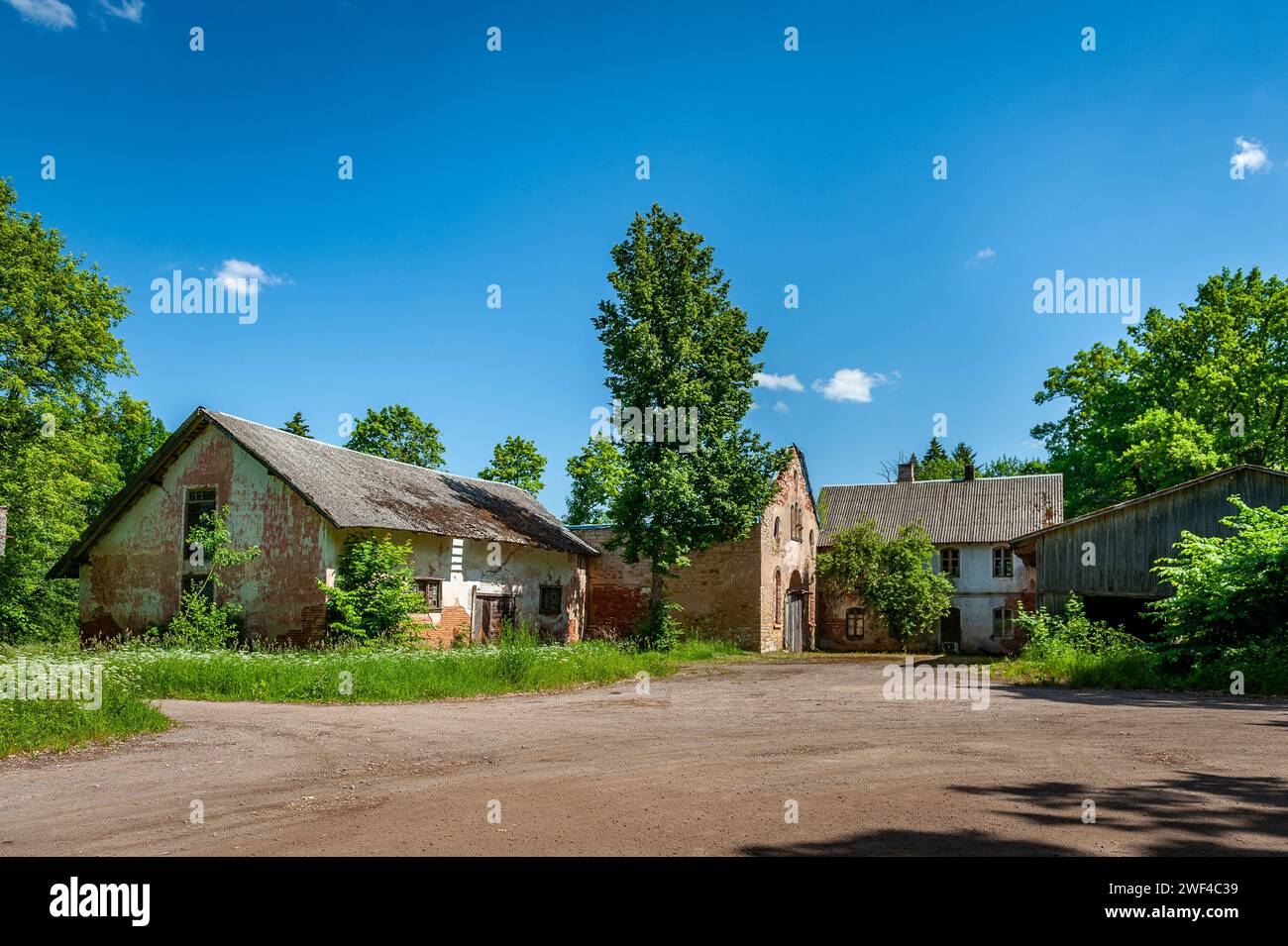 Backsteingebäude und hölzerne Nebengebäude, Überreste eines zerstörten Anwesens. Manor Aumeisteri, Lettland. Stockfoto