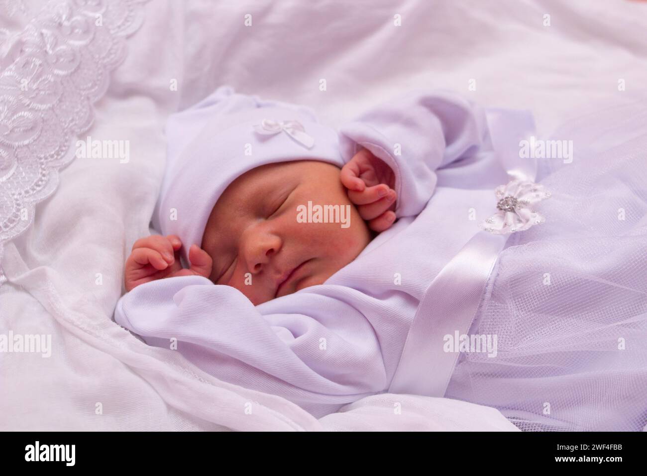 Baby schläft in einem Traum Emotionen, schönes Baby schläft in einem weißen Kleid Stockfoto